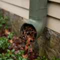 Blocked gutter downspout preventing proper water drainage