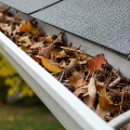 Leaves and debris collected inside a residential gutter